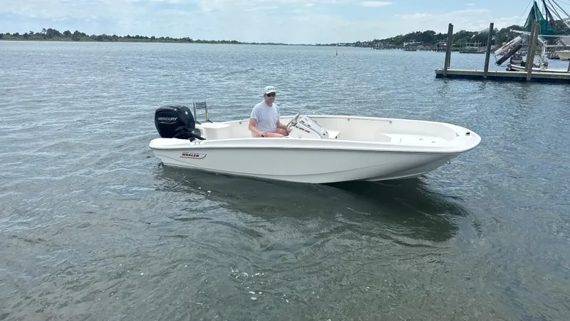 Slide: The Image of 2023 Boston Whaler 160 Super Sport boat on calm water with a person onboard. - 13