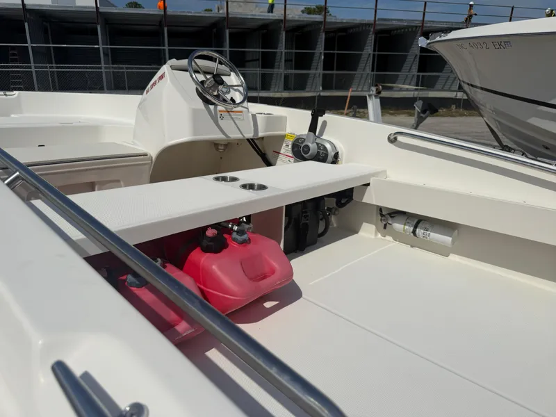 Slide: The Image of 2023 Boston Whaler 160 Super Sport interior with steering wheel and red fuel tank. - 19