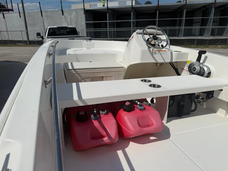 Slide: The Image of 2023 Boston Whaler 160 Super Sport interior with steering console and fuel containers. - 20