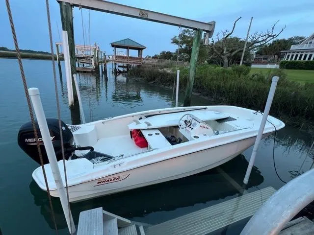 Slide: The Image of 2023 Boston Whaler 160 Super Sport boat docked on calm water. - 5