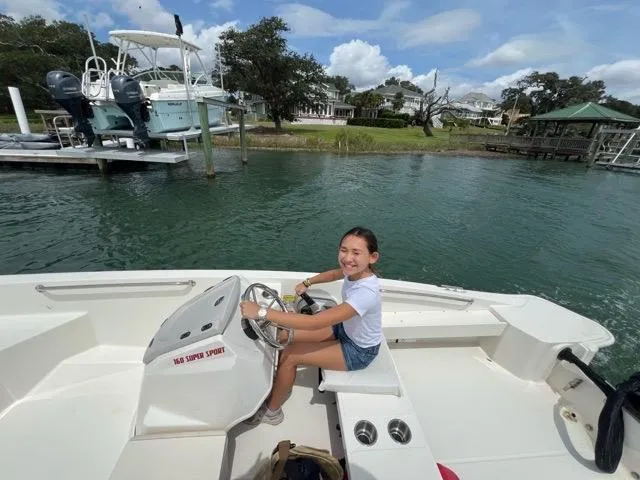 Slide: The Image of Young person steering a 2023 Boston Whaler 160 Super Sport on a sunny day. - 6