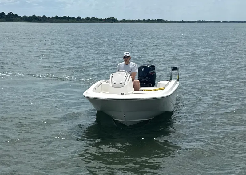 Slide: The Image of 2023 Boston Whaler 160 Super Sport boat on open water, with a person onboard. - 7