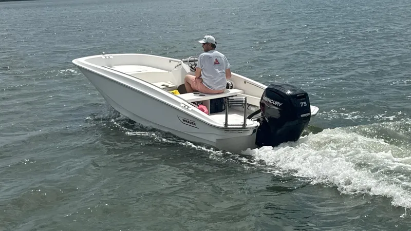 Slide: The Image of 2023 Boston Whaler 160 Super Sport boat cruising on water with Mercury engine. - 9