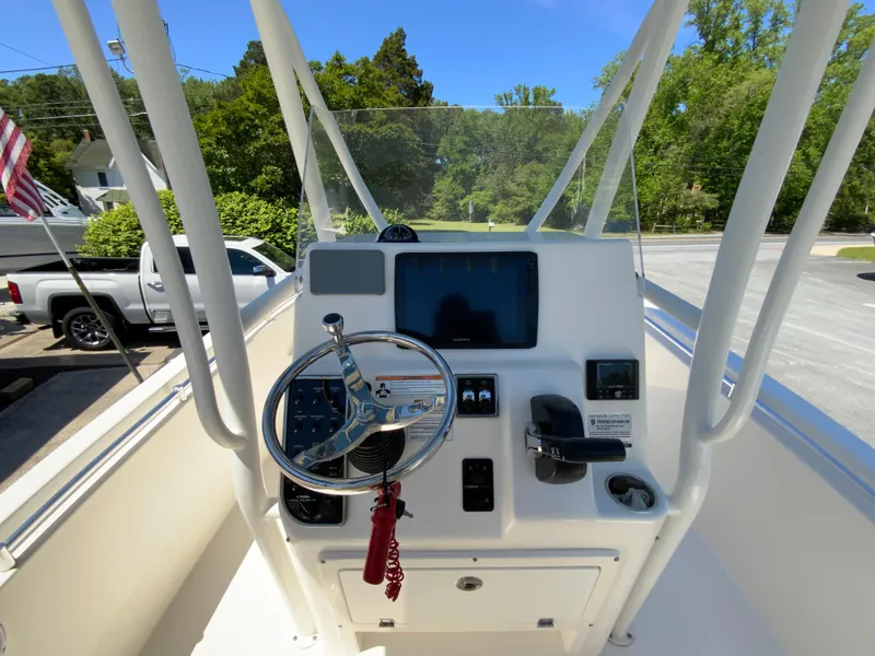 Slide: The Image of 2019 Cobia 220 Center Console boat dashboard with steering wheel and navigation display. - 11