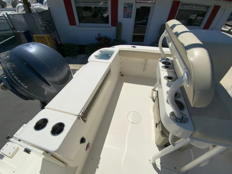 Slide: The Image of 2019 Cobia 220 Center Console boat interior with Yamaha engine, rod holders, and seating. - 13