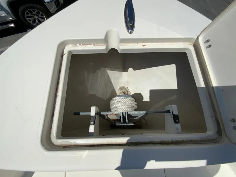 Slide: The Image of 2019 Cobia 220 Center Console anchor storage compartment with rope and anchor inside. - 18