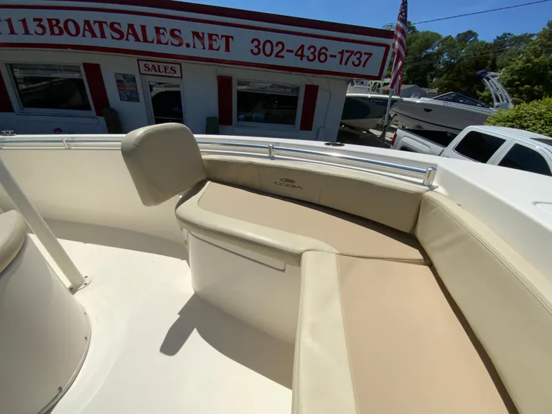 Slide: The Image of 2019 Cobia 220 Center Console boat interior at dealership, featuring cushioned seating. - 21