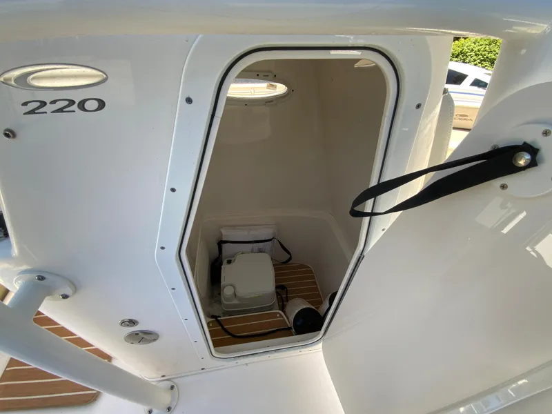 Slide: The Image of 2019 Cobia 220 Center Console boat interior with open hatch and visible storage area. - 25