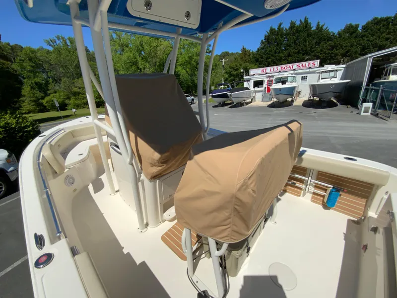 Slide: The Image of 2019 Cobia 220 Center Console boat with covered seats, parked outdoors. - 30