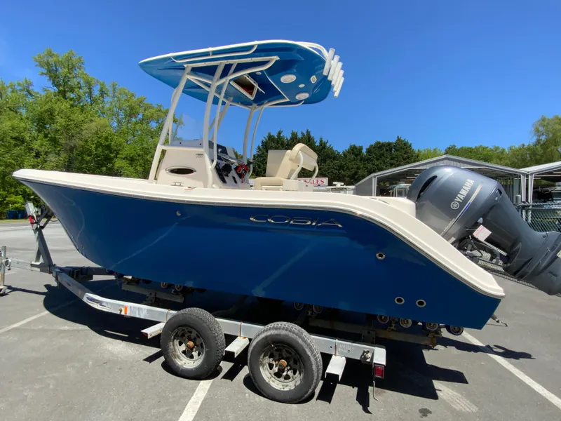 Slide: The Image of 2019 Cobia 220 Center Console boat on trailer, blue hull, Yamaha outboard, sunny day. - 6