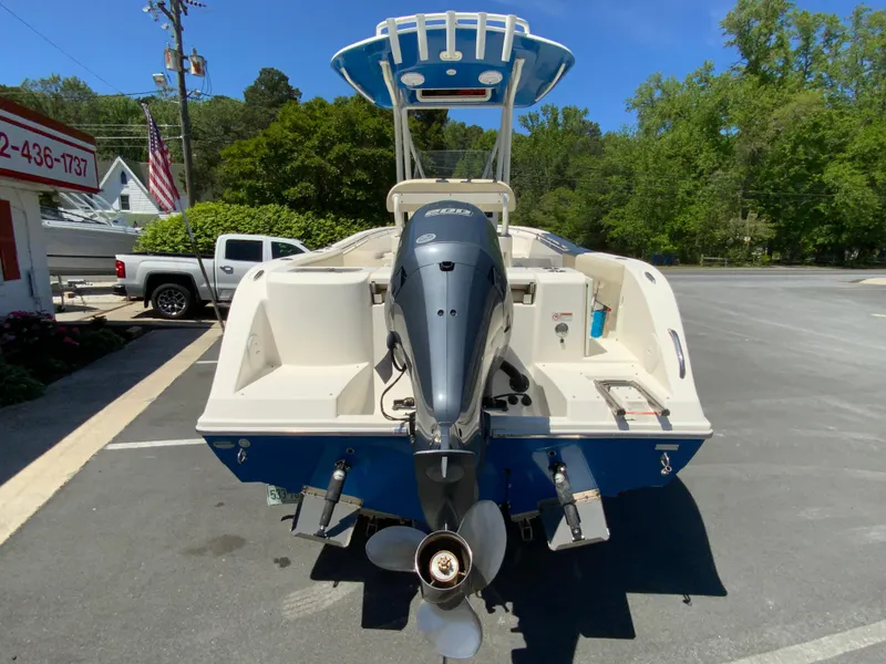 Slide: The Image of 2019 Cobia 220 Center Console boat with outboard motor, parked outdoors. - 8