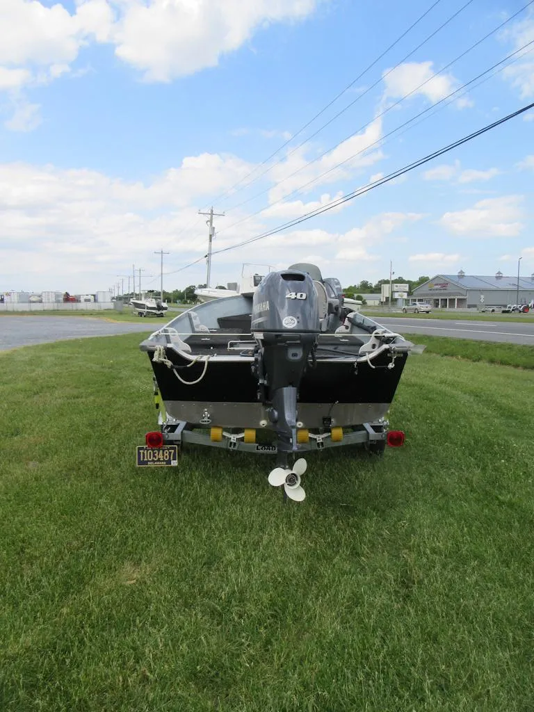 Slide: The Image of 2018 Starcraft SF DLX 16 boat on grass, rear view, with outboard motor. - 3