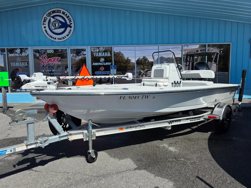 Slide: The Image of 2024 Hewes Redfisher 18 boat on trailer outside marine dealership. - 2