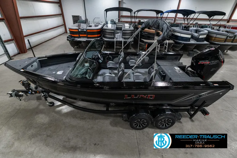 The Image of 2025 Lund 1975 Tyee boat in showroom, black exterior, modern design, trailer attached. - 1