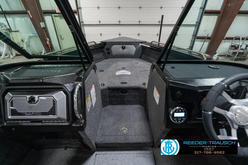 Slide: The Image of Interior view of 2025 Lund 1975 Tyee boat, featuring modern dashboard and spacious seating. - 16