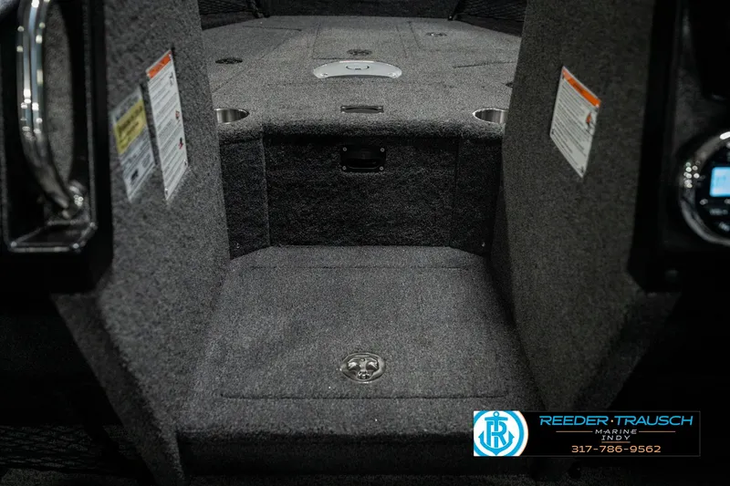 Slide: The Image of Interior of 2025 Lund 1975 Tyee boat, featuring carpeted flooring and storage compartments. - 27