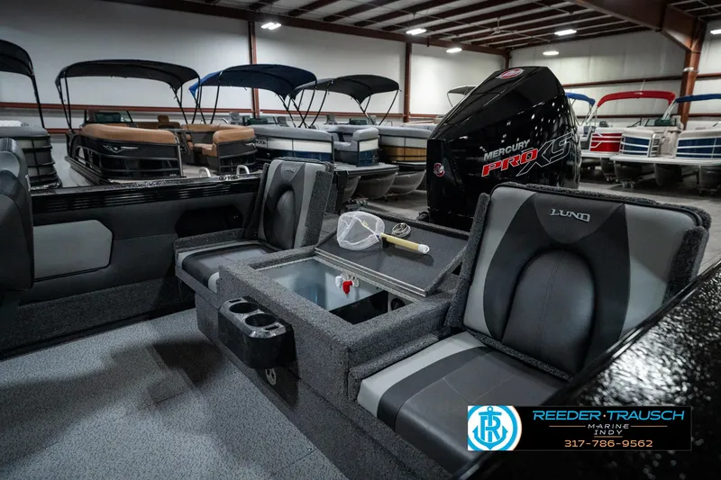Slide: The Image of 2025 Lund 1975 Tyee boat interior with Mercury engine, showcased in a showroom. - 37