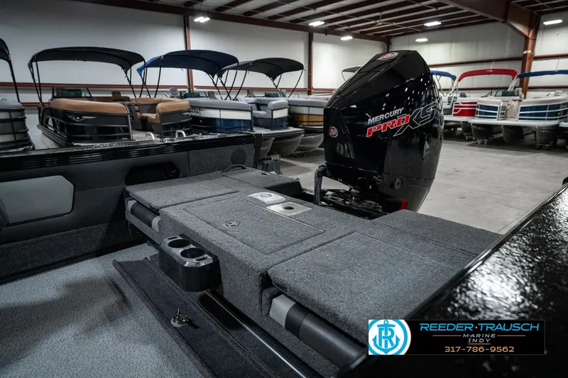 Slide: The Image of 2025 Lund 1975 Tyee boat interior with Mercury engine, displayed in a showroom. - 39