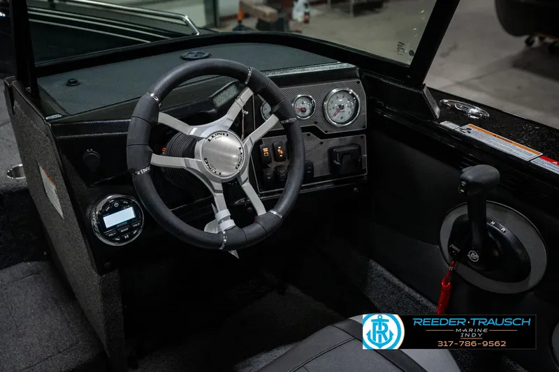Slide: The Image of Interior view of 2025 Lund 1975 Tyee boat, featuring steering wheel and dashboard controls. - 41