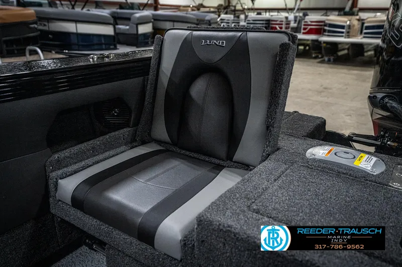 Slide: The Image of 2025 Lund 1975 Tyee boat seat in a showroom, featuring gray and black upholstery. - 49