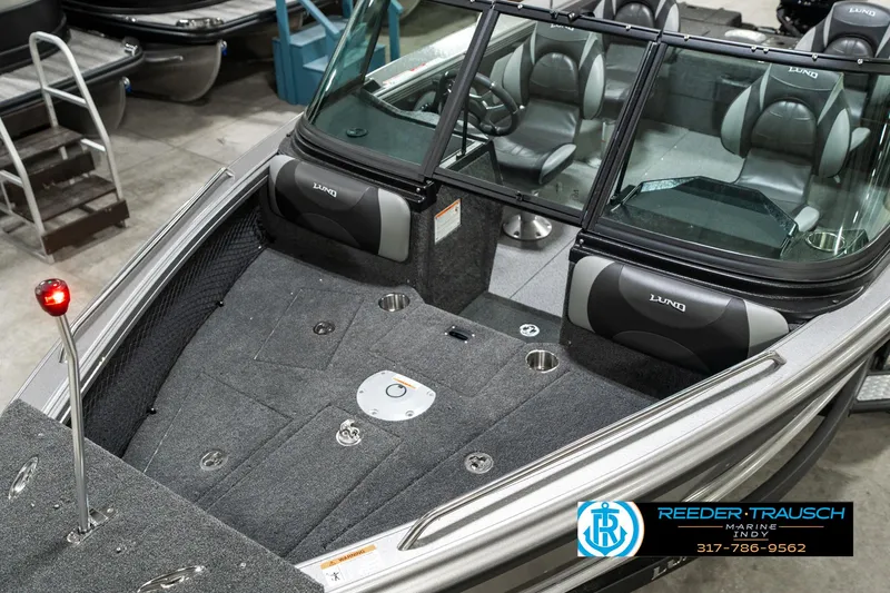 Slide: The Image of 2025 Lund 1875 Tyee boat interior with seating and dashboard, displayed indoors. - 12