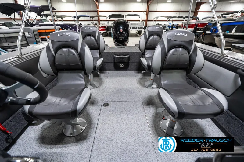 Slide: The Image of 2025 Lund 1875 Tyee boat interior with four gray seats in a showroom. - 20