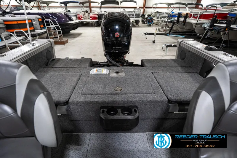 Slide: The Image of 2025 Lund 1875 Tyee boat interior with motor, showcased in a showroom. - 21