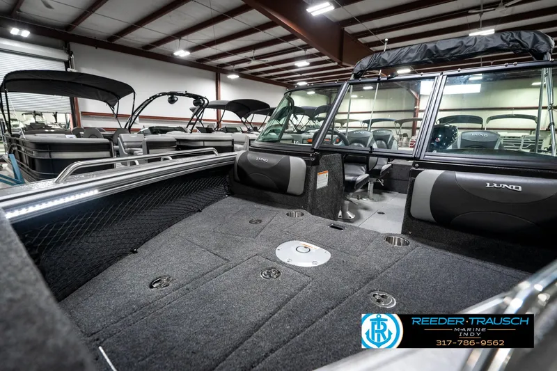 Slide: The Image of 2025 Lund 1875 Tyee boat interior in showroom, featuring spacious seating and modern design. - 22