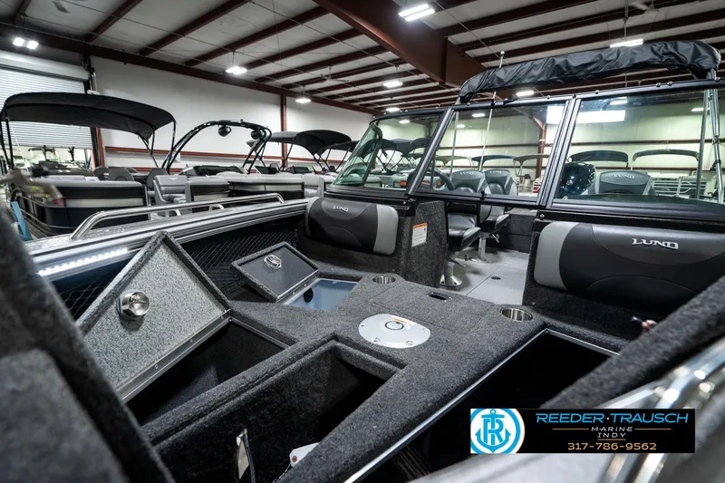 Slide: The Image of 2025 Lund 1875 Tyee boat interior with storage compartments in a showroom. - 23