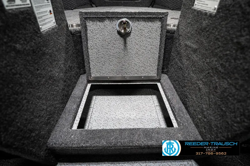 Slide: The Image of 2025 Lund 1875 Tyee boat storage compartment with carpeted interior and secure latch. - 28