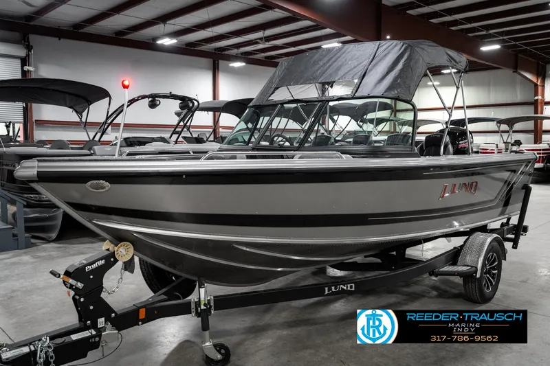 Slide: The Image of 2025 Lund 1875 Tyee boat in showroom, on trailer, with canopy, side view. - 3