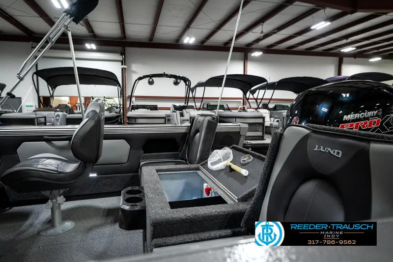 Slide: The Image of 2025 Lund 1875 Tyee boat interior with seating and storage, displayed in a showroom. - 35
