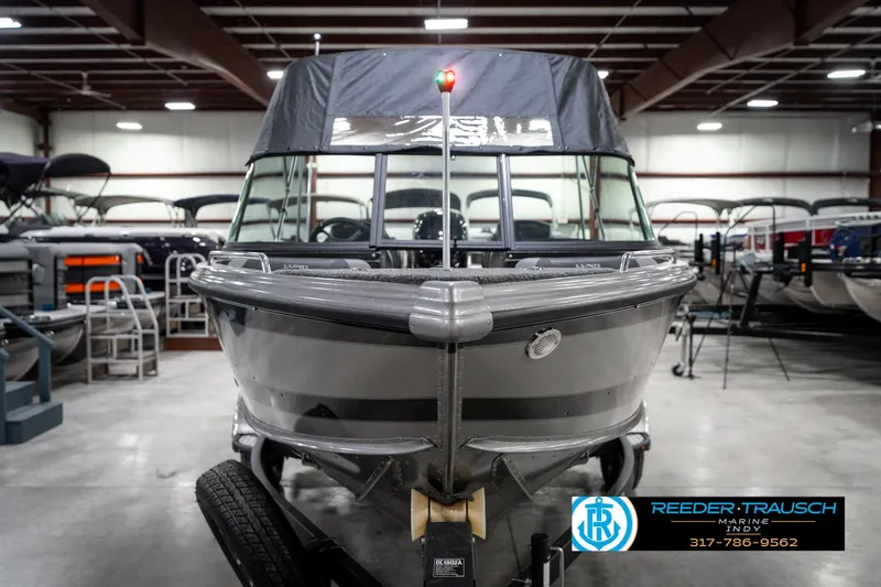 Slide: The Image of 2025 Lund 1875 Tyee boat in showroom, front view, on trailer, with protective cover. - 5