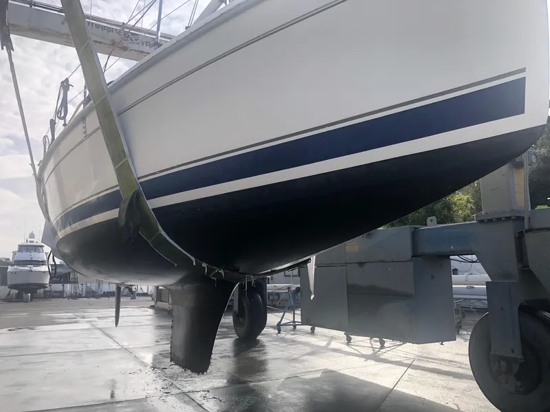 Slide: The Image of 2008 Hunter 31 sailboat in dry dock, hull view with blue stripe. - 20