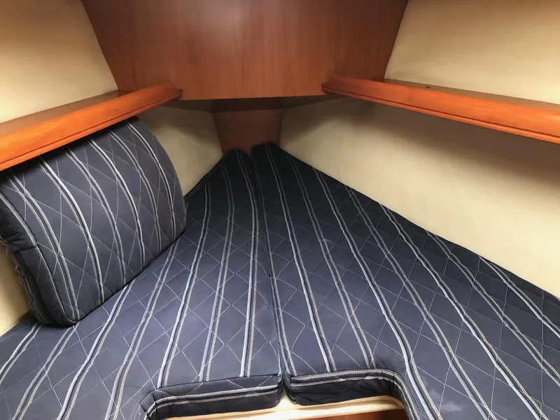Slide: The Image of 2008 Hunter 31 sailboat cabin with striped cushions and wooden shelves. - 6