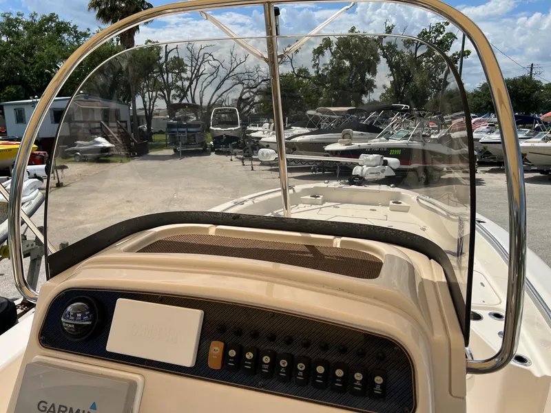 Slide: The Image of 2014 Grady-White 251 Coastal Explorer boat dashboard with clear windshield and control panel. - 21