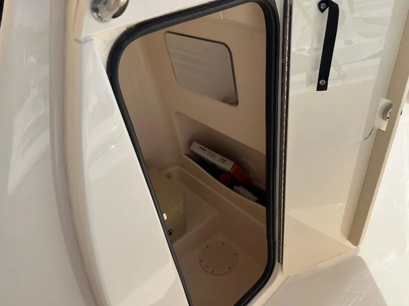 Slide: The Image of 2014 Grady-White 251 Coastal Explorer storage compartment with safety equipment. - 27