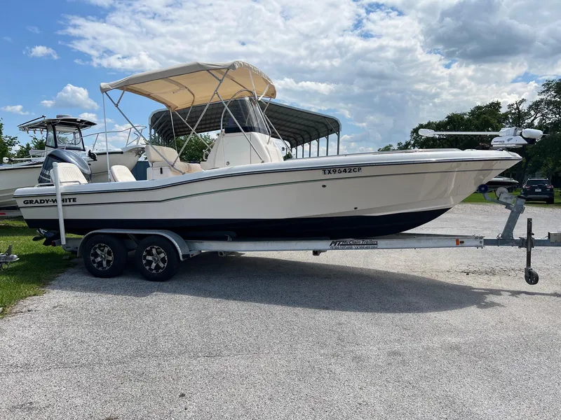 Slide: The Image of 2014 Grady-White 251 Coastal Explorer boat on trailer, parked outdoors under cloudy sky. - 39