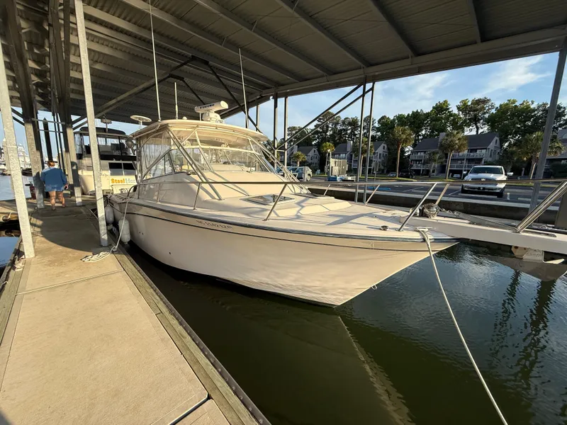 Slide: The Image of 2002 Grady-White Express 330 boat docked under a covered marina. - 10