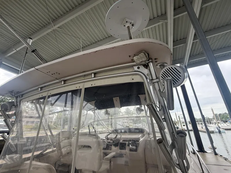 Slide: The Image of 2002 Grady-White Express 330 boat under a covered dock, showcasing helm and radar equipment. - 13