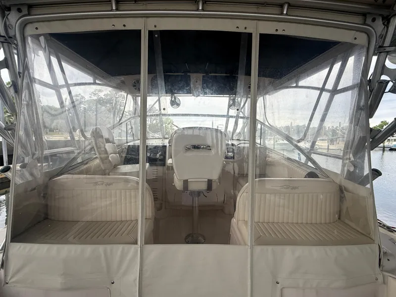 Slide: The Image of 2002 Grady-White Express 330 boat interior with seating and helm, enclosed by clear panels. - 14