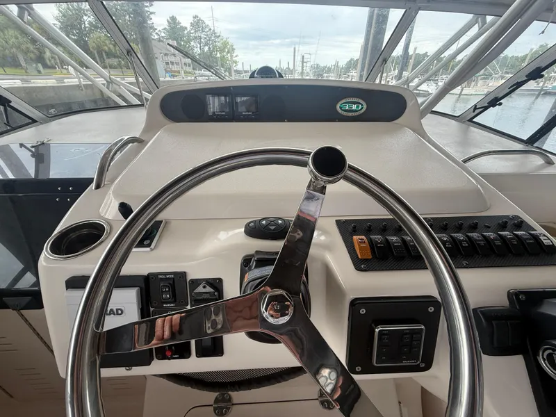 Slide: The Image of 2002 Grady-White Express 330 helm with steering wheel and control panel. - 16