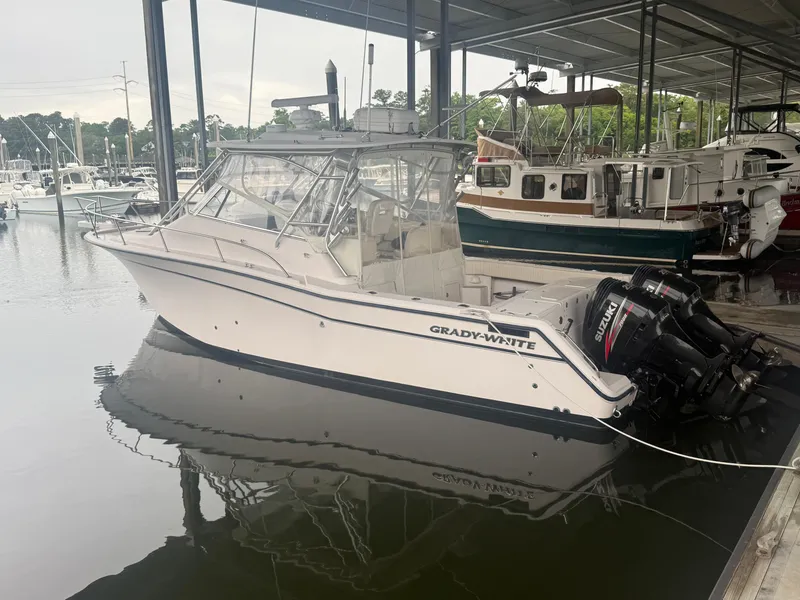 Slide: The Image of 2002 Grady-White Express 330 boat docked in a marina, featuring twin outboard engines. - 2