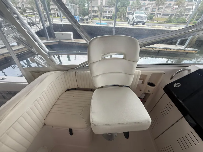 Slide: The Image of Captain's chair on 2002 Grady-White Express 330 boat, featuring white upholstery and panoramic windows. - 20