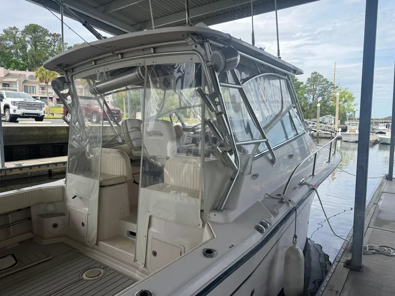 Slide: The Image of 2002 Grady-White Express 330 boat docked under a covered marina. - 23