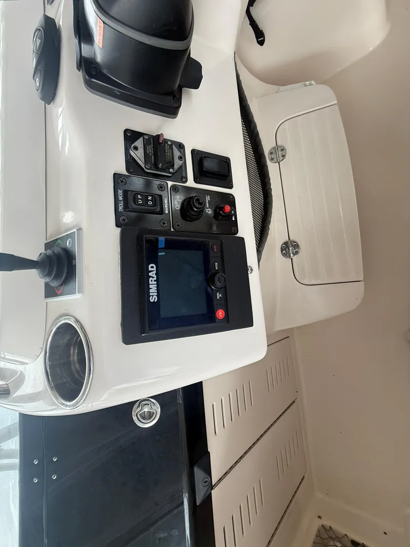 Slide: The Image of 2002 Grady-White Express 330 boat dashboard with navigation controls and Simrad display. - 24