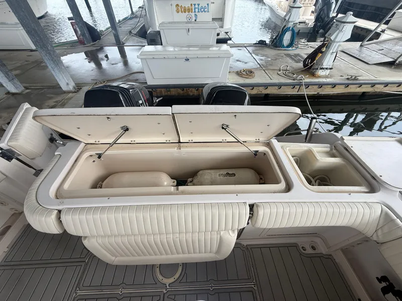 Slide: The Image of 2002 Grady-White Express 330 boat with open storage compartments at a marina. - 25