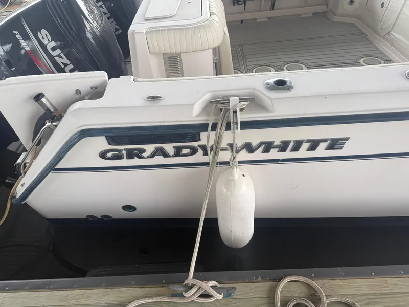Slide: The Image of 2002 Grady-White Express 330 boat docked with visible fender and Suzuki outboard motor. - 26