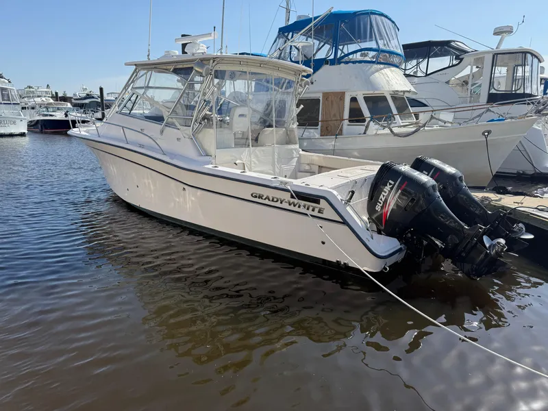 Slide: The Image of 2002 Grady-White Express 330 boat docked at marina with twin outboard engines. - 27