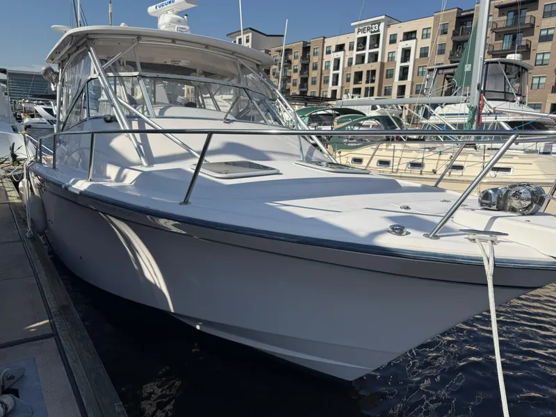 Slide: The Image of 2002 Grady-White Express 330 boat docked at marina, sunny day, waterfront buildings. - 29